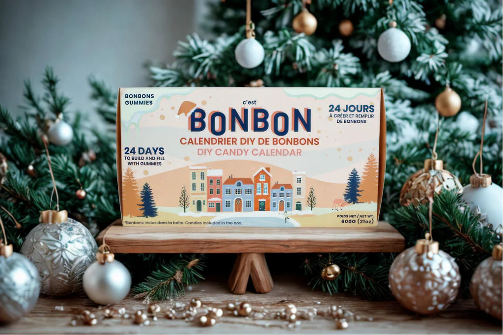 Calendrier de l'Avent 'C'Est Bonbon' in front of a Christmas tree with advent ornaments 