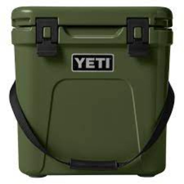YETI Roadie 24 hard cooler with two heavy duty latches on lid and a shoulder strap in highlands olive